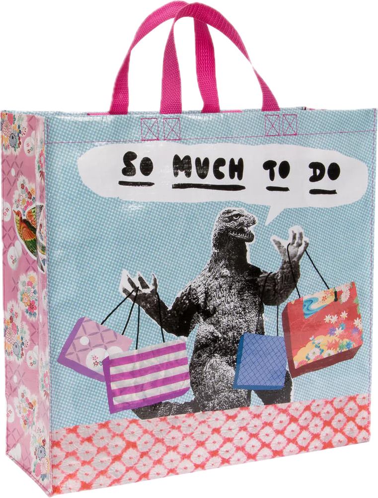 A tote bag featuring a classic Godzilla holding a bunch of tote bags with a speech bubble reading "so much to do"